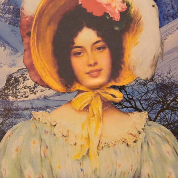 En kvinne i vintagekjole og stor hatt med blomster poserer foran et snødekt fjellandskap.