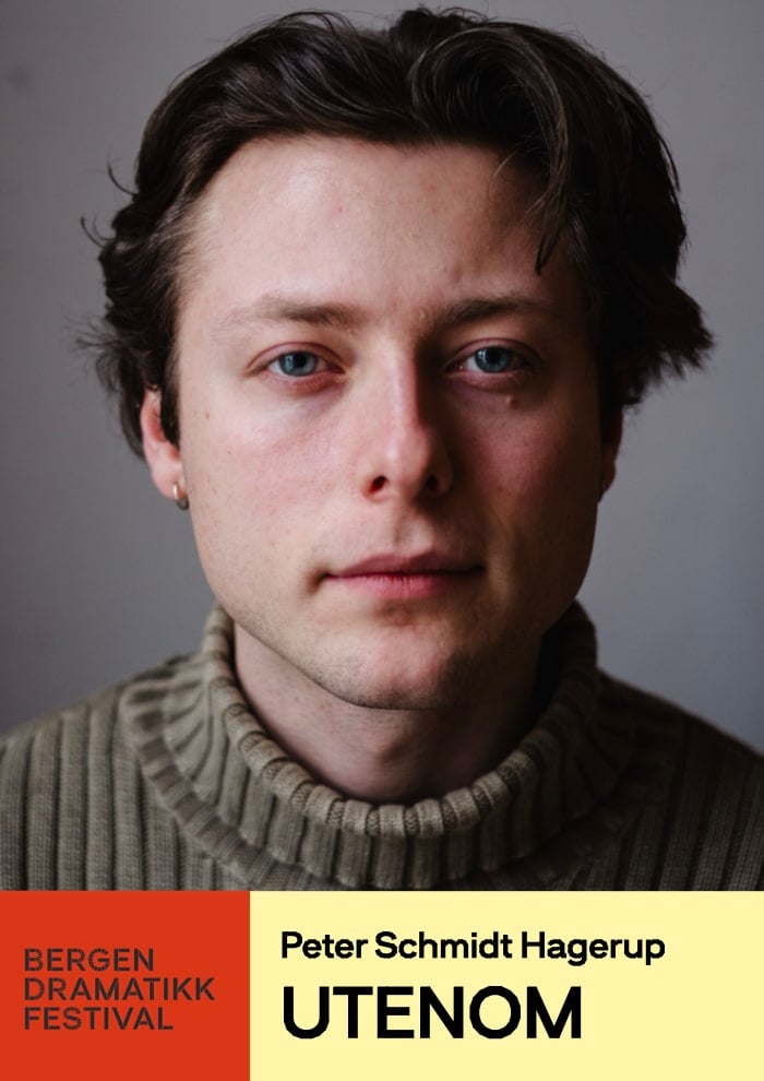 Et pinneinsekt står på et tregulv inne i et rom med runde vinduer, en lysestake og mørkt tapet. På bildet står det blant annet "TRIGGERSYSTEMET" og "Transiteteatret-Bergen".