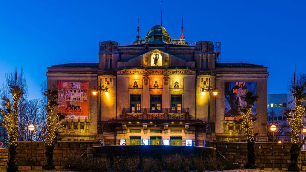 Det kongelige dramatiske teateret i stockholm i skumringen, opplyst av utvendige lys.